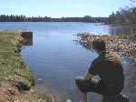 Man sitting on the shore of First Lake, Sackville, Nova Scotia.