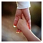 Photo de la main d'un adulte tenant la main d'un enfant