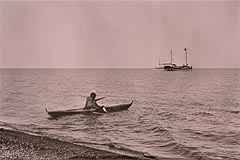 Inuvialuit man in a kayak checks his fishing nets