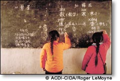 Two girls writing on a black board
 ACDI-CIDA/Roger LeMoyne