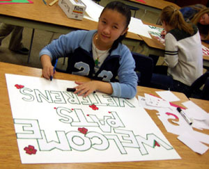 A grade 10 student prepares a poster for the tribute.