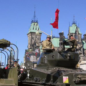Des acteurs de reconstitution du temps de guerre sont assis dans un char d'assaut de la Seconde Guerre mondiale avant le début de la cérémonie du 60e anniversaire du Jour de la Victoire en Europe, à Ottawa. 