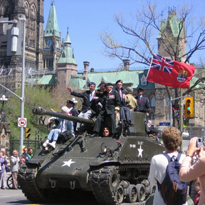 Défilé du Jour de la Victoire en Europe - D'un char d'assaut d'époque, des anciens combattants saluent la foule alignée le long de la rue Wellington, à Ottawa.