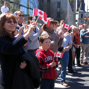 Des milliers de Canadiens et de Canadiennes sont alignés le long des rues pour acclamer les anciens combattants du Canada. 