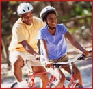 Two people riding bicycles and wearing helmets