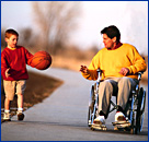 Photo of an adult in a wheel chair throwing a basketball to a boy