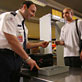 Homme franchissant un point de contrôle de sécurité à un aéroport avec un bagage de cabine