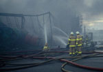 Firefighters controlling a fire at industrial plant.