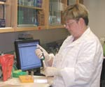 Technicien de Santé Canada effectuant, au Laboratoire national de microbiologie de Winnipeg, un test initial (ELISA) de dépistage du virus du Nil occidental.