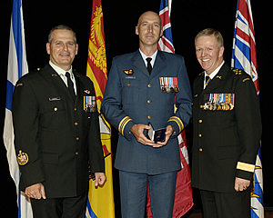 Chief Warrant Officer Gregoire Lacroix (left) and Chief of Defence Staff General Rick Hillier (right) present Major Gregory Allan Penner (middle) with a Mentioned in Dispatches Award at a formal ceremony. Credit: Cpl Marcie Lane, CFSU(O) Photo Services.