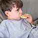 Photo d'un garçon regardant la télévision et mangeant un biscuit