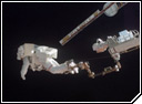 NASA astronaut Scott Parazynski anchored at the end of the Shuttle's Canadian-built boom extension and attached to the Canadarm2