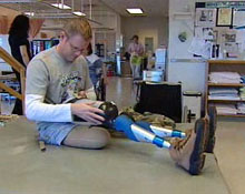 Master Cpl. Paul Franklin adjusts one of his artificial legs before one of his rehabilitation sessions in 2006.