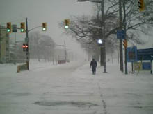 A pedestrian walks through the snow along St. Clair Avenue West in Toronto on Sunday morning.