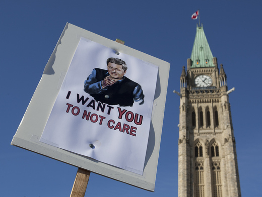 The Peace Tower is seen behind a sign of Prime Minister Stephen Harper during a anti-prorogation protest in Ottawa on Saturday. (Pawel Dwulit / The Canadian Press)