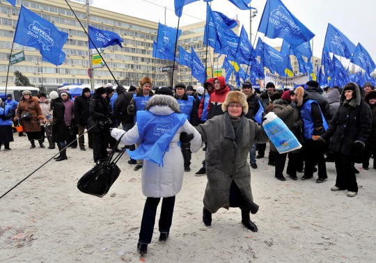 Supporters of Ukrainian opposition leader and presidential candidate Viktor Yanukovych dance holding flags of the Party of Regions during a rally, in front of Central Election Commission, in Kiev, Ukraine, Wednesday, Feb. 10, 2010. (AP Photo/Sergei Chuzavkov)
