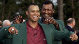Tiger Woods of the U.S. smiles as he receives the traditional green jacket from former winner Vijay Singh of Fiji to signify his win of the Masters at Augusta National Golf Club in this April 8, 2001 file photo. Woods, at the age of 25, coolly sank a 15-foot birdie putt on the 18th green at Augusta National on April 8, 2001, to win his second Masters crown and put his name into the record books as the only player to hold all four of golf's major titles at the same time. Picture taken fy his win of the Masters at Augusta National Golf Club in this April 8, 2001. To match feature -DECADE/GOLF REUTERS/Kevin Lamarque