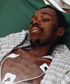 Evans Monsigrace lies on a stretcher inside a University of Miami field hospital in Port-au-Prince. Michael Kastenbaum/Reuters