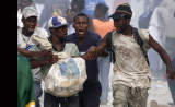Looters fight for a bag of materials in Haitian capital Port-au-Prince on Saturday, Jan. 16, 2010. The situation in Haiti is worsened by occasional looting in the aftermath of a devastating earthquake on Jan. 12.