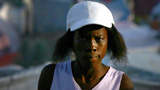 A woman stands outside her tent in the camp for displaced people at Port-au-Prince's only golf club.