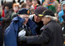 A Veteran is given a warm coat during the Remembrance Day Ceremony at the National War Monument in Ottawa. November 11, 2011. (Photo by Jason Ransom)
