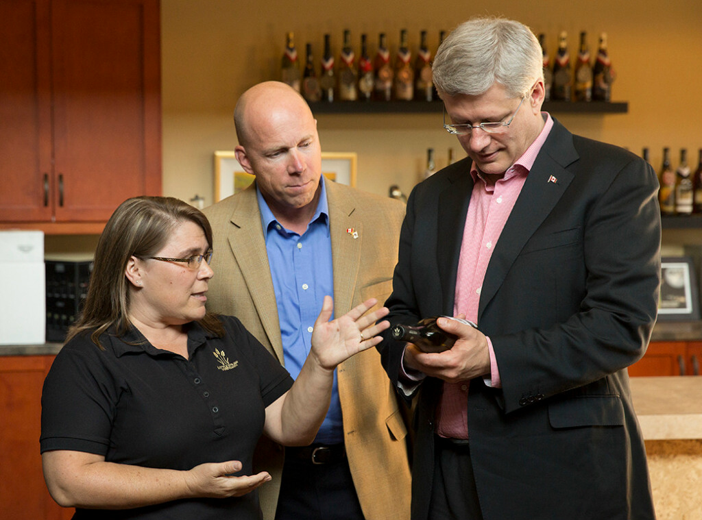 Le Premier ministre Stephen Harper regarde diffrents vins avec le dput Ron Cannan et la grante de Little Straw Winery, Tina Slamka,  Kelowna, en Colombie-Britannique, le 13 septembre 2013. (Photo par Jason Ransom)