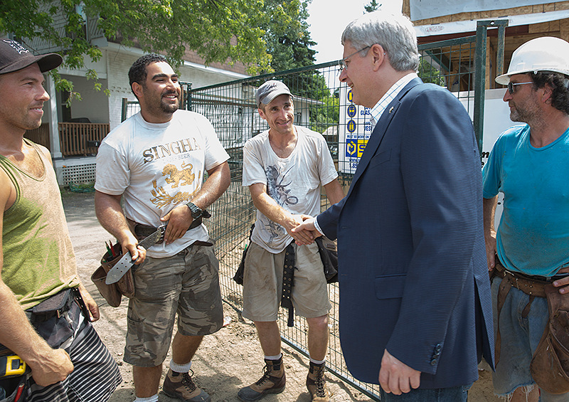 Le Premier ministre Stephen Harper salue un groupe de constructeurs d'habitations  Ottawa le 18 juillet 2013. (Photo du CPM par Jason Ransom)