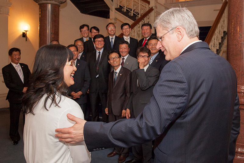 Le Premier ministre Stephen rit avec le snateur Yonah Martin durant une sance de photos en compagnie du prsident de la section rgionale de la United Korean Commerce and Industry Association  Ottawa. 31 mai 2013. (Photo par Jason Ransom)
