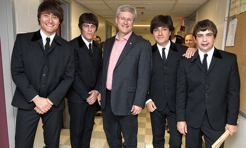 Le Premier ministre Stephen Harper pose pour une photo avec des membres du groupe Rain, qui rend hommage aux Beatles, avant de voir leur spectacle au thtre Centrepointe d'Ottawa. 10 aot 2012. (Photo par Jill Thompson)