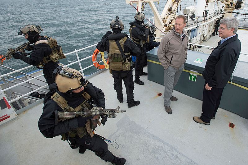 Le Premier ministre Stephen Harper et Peter MacKay, ministre de la Dfense nationale, observent des membres des Forces armes canadiennes monter  bord d'un navire d'intrt durant l'Opration NANOOK. Le 24 aot 2012. (Photo par Jason Ransom)

