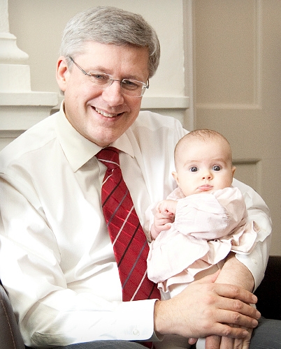 Le Premier ministre Stephen Harper passe un moment avec l?enfant d?un de ses employs. Le 4 mars 2011. (Photo de Jill Thompson)