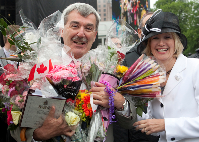 Mme Harper change un sourire avec Kevin MacLeod, l'huissier du bton noir,  qui on a demand de porter les cadeaux faits  la Reine lors d'un bain de foule  Halifax. Le 28 juin 2010. (Photo de Jason Ransom)
