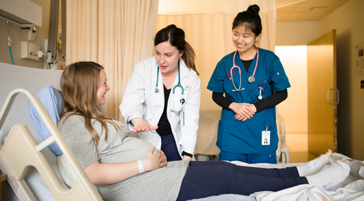 A nurse talking to a pregnant patient with a doctor