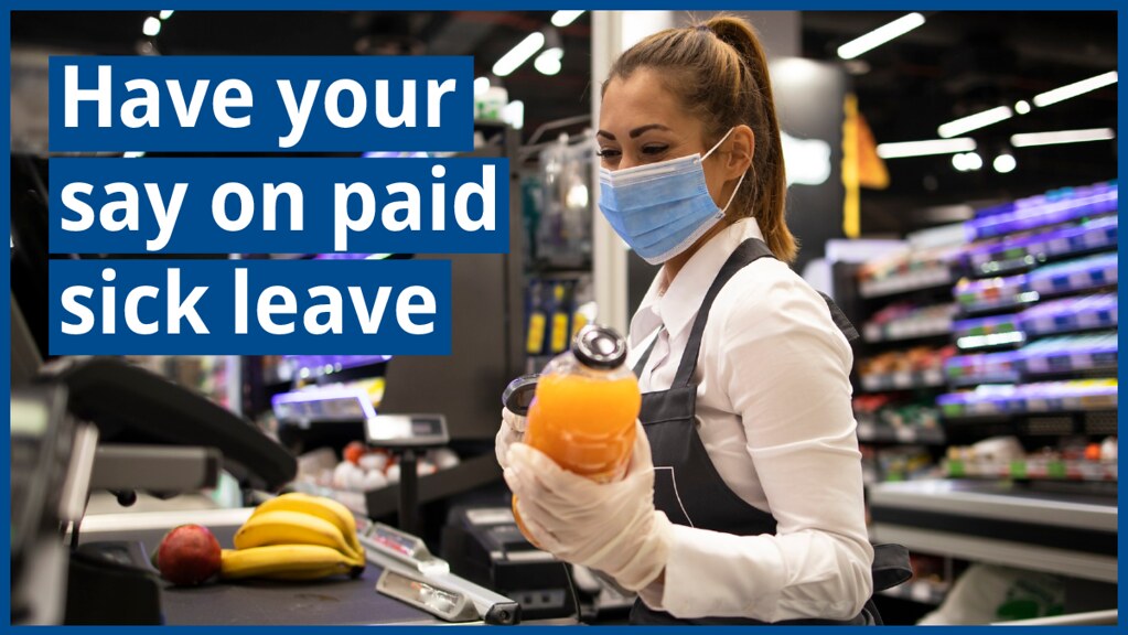 A masked grocery store clerk scans juice. Text on image "Have your say on paid sick leave"